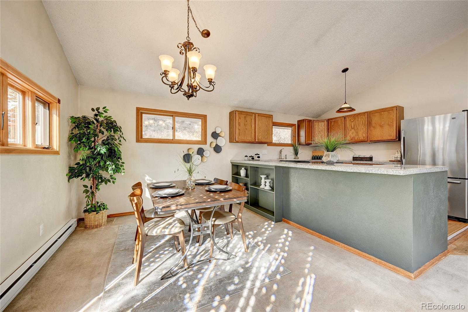 32856 Timber Ridge Road Evergreen, CO 80439 - Photo 7 of 41 a kitchen with stainless steel appliances kitchen island granite countertop a sink and a refrigerator