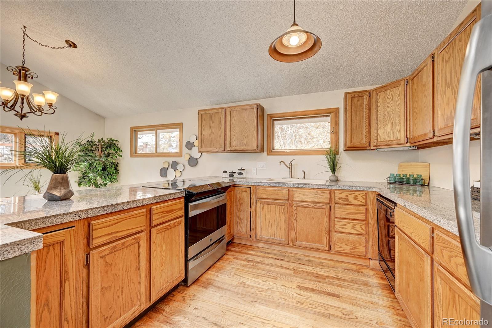 32856 Timber Ridge Road Evergreen, CO 80439 - Photo 9 of 41 a kitchen with stainless steel appliances granite countertop a sink stove and cabinets