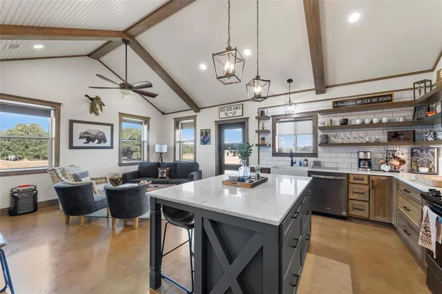 a open kitchen with stainless steel appliances granite countertop a stove a refrigerator a sink dishwasher a dining table and chairs with wooden floor