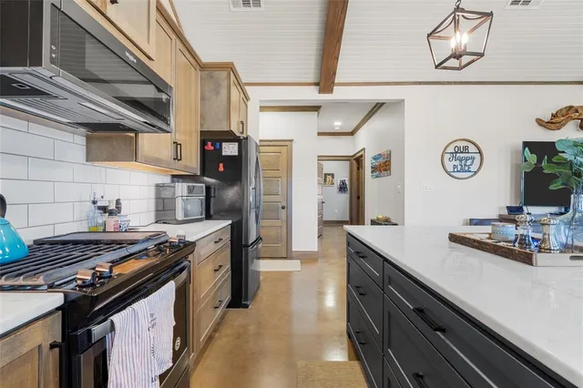 a kitchen with stainless steel appliances a stove a sink and cabinets