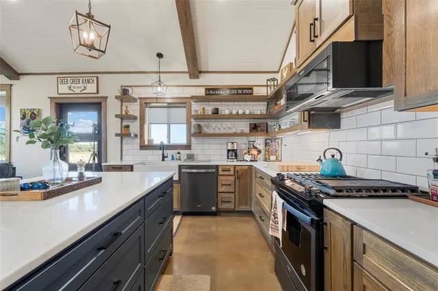 a kitchen with stainless steel appliances granite countertop a sink and stove