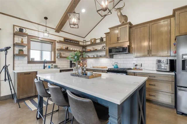 a kitchen with a table chairs microwave and cabinets