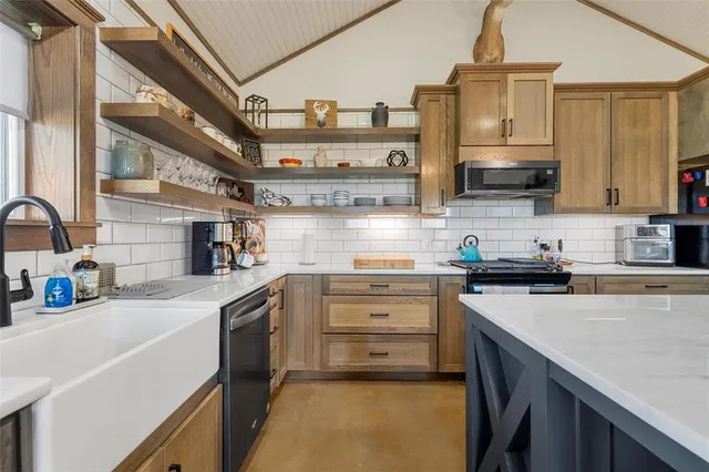 a kitchen with stainless steel appliances a sink stove and cabinets