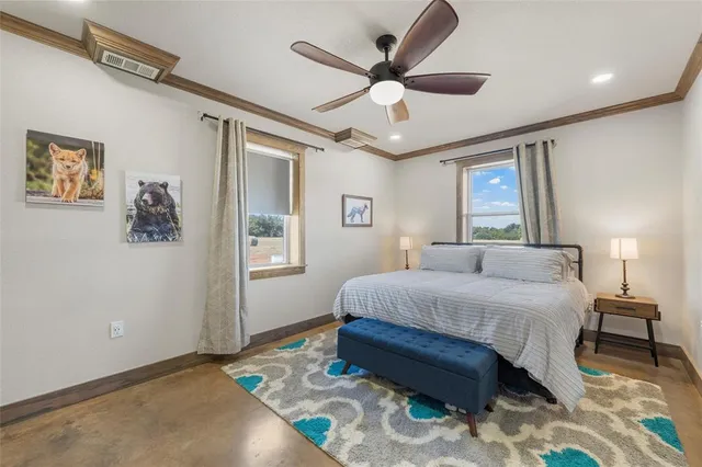 a bedroom with a large bed chandelier and a window