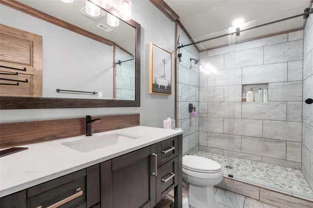 a bathroom with a sink a toilet and shower