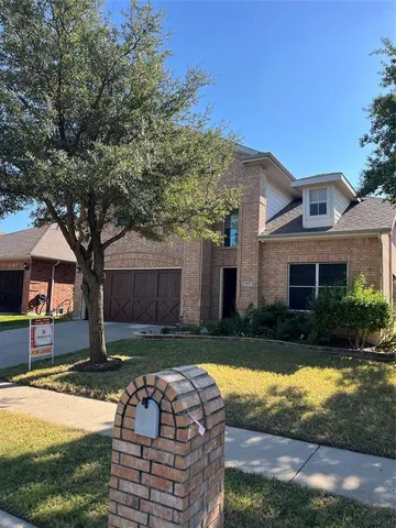 a front view of brick house with yard and trees