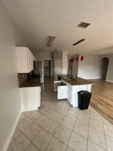 en empty room with windows and ceiling fan