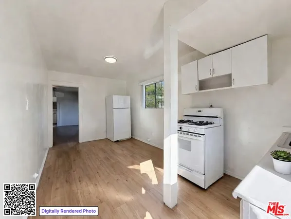 a view of a kitchen with white cabinets and wooden floor