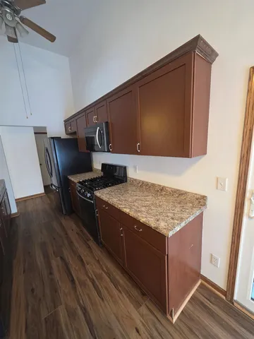 a kitchen with stainless steel appliances granite countertop a stove and a wooden floors