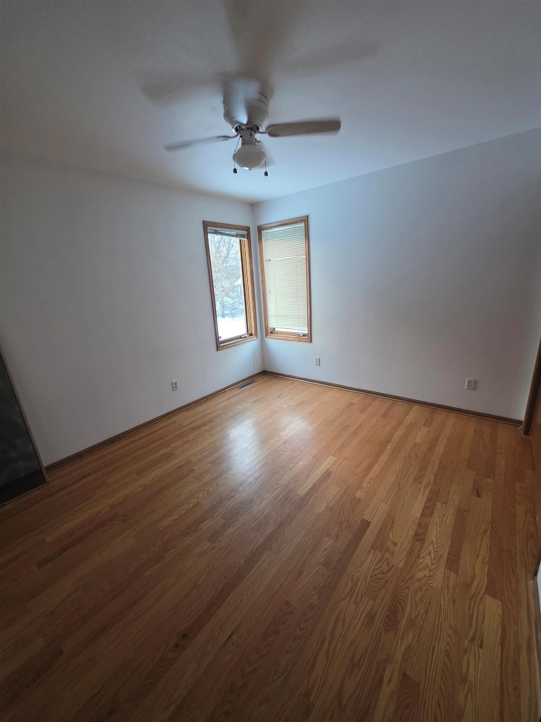 205 Gables Drive Southwest Poplar Grove, IL 61065 - Photo 5 of 33 an empty room with wooden floor chandelier fan and windows