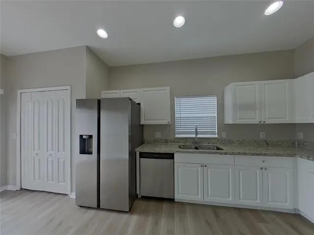 a kitchen with stainless steel appliances granite countertop a refrigerator and a stove top oven