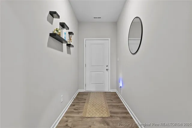 a view of a room with wooden floor and white walls