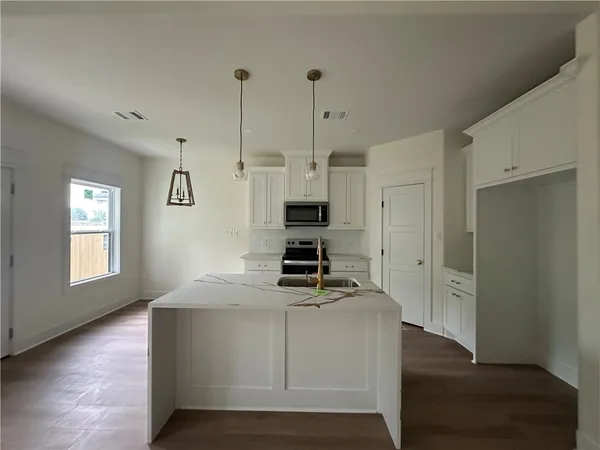 a kitchen with kitchen island a counter top space a sink and appliances