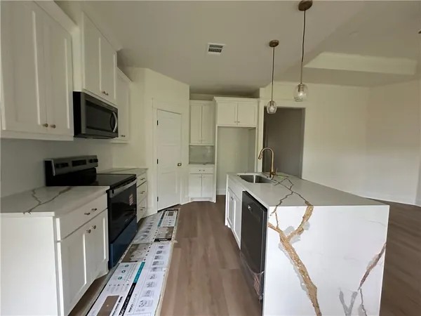 a kitchen with stainless steel appliances a stove a sink and a refrigerator