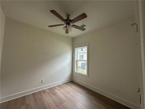 an empty room with windows and fan
