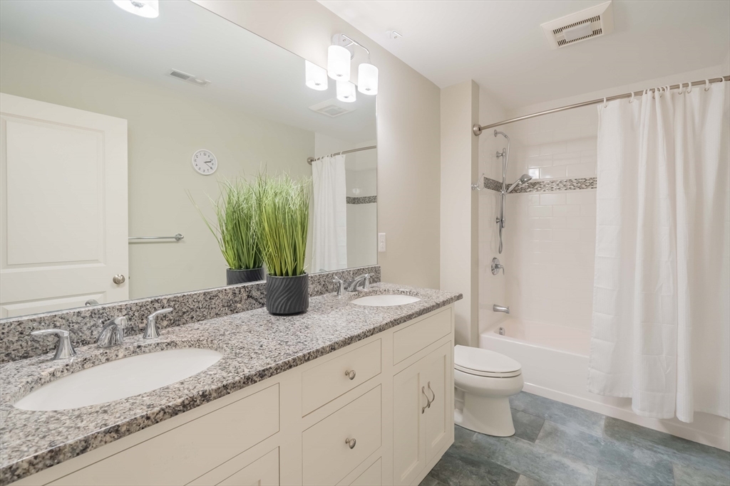 15 Hickory Street Lexington, MA 02421 - Photo 31 of 42 a bathroom with a granite countertop sink a toilet and a large mirror