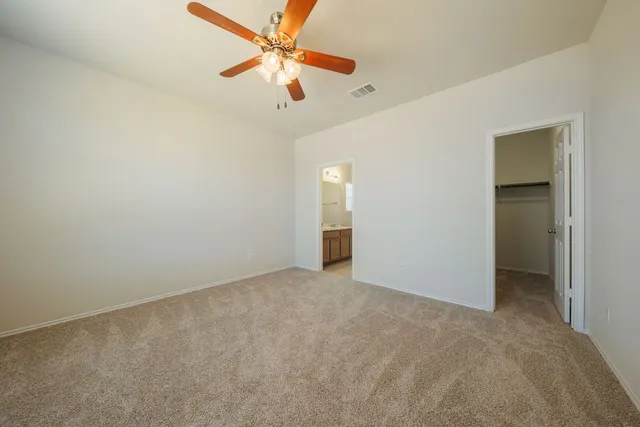 an empty room with closet and a chandelier fan