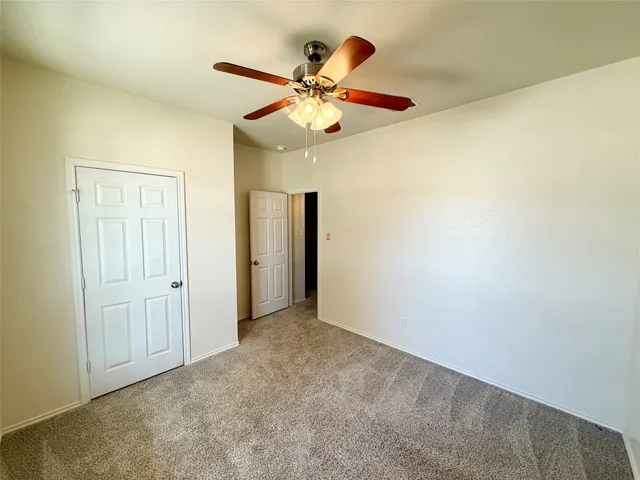 an empty room with a ceiling fan and a ceiling fan