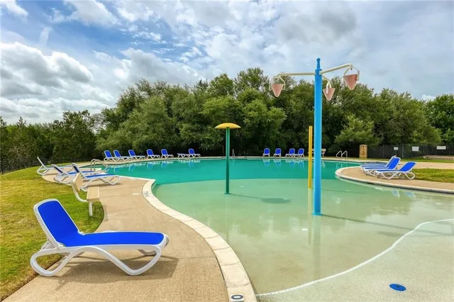 a view of a swimming pool with a patio and a yard