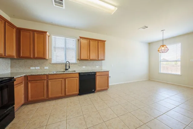 a large kitchen with granite countertop a sink a stove a cabinets and a window