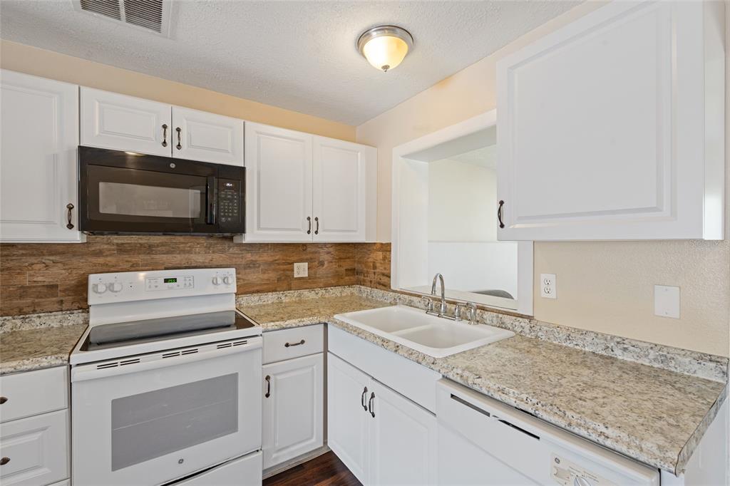 a kitchen with appliances a sink and cabinets