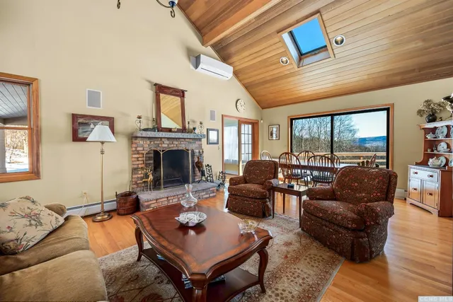 a living room with furniture a fireplace and a large window