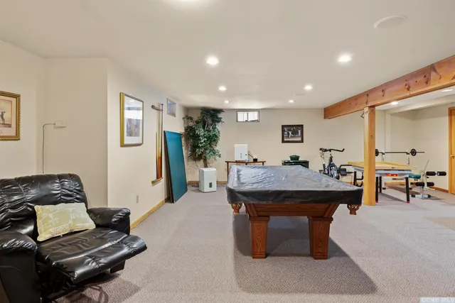 a room with furniture pool table and window