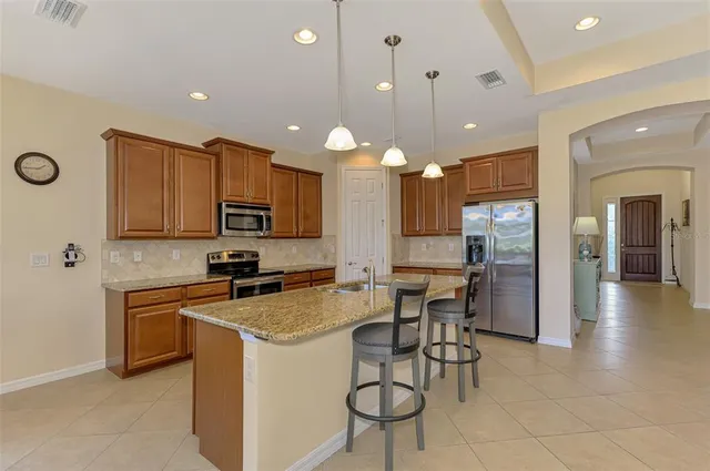 a living room with furniture kitchen view and a large window