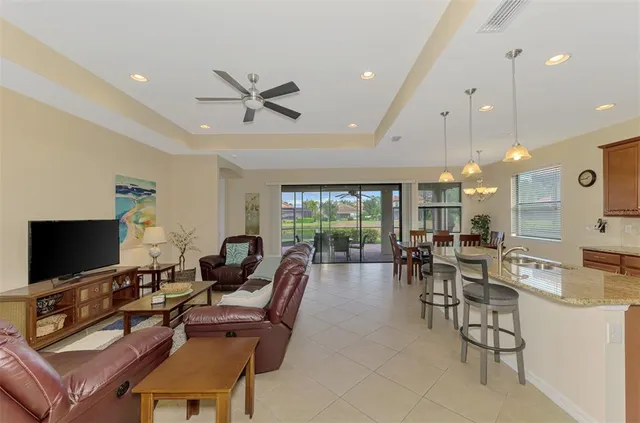 a living room with furniture a flat screen tv and kitchen view