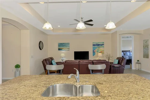 a open kitchen with stainless steel appliances granite countertop a stove top oven a sink dishwasher a dining table and chairs with wooden floor