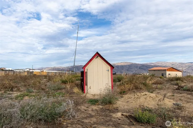 a view of a dry yard with mountains in the background