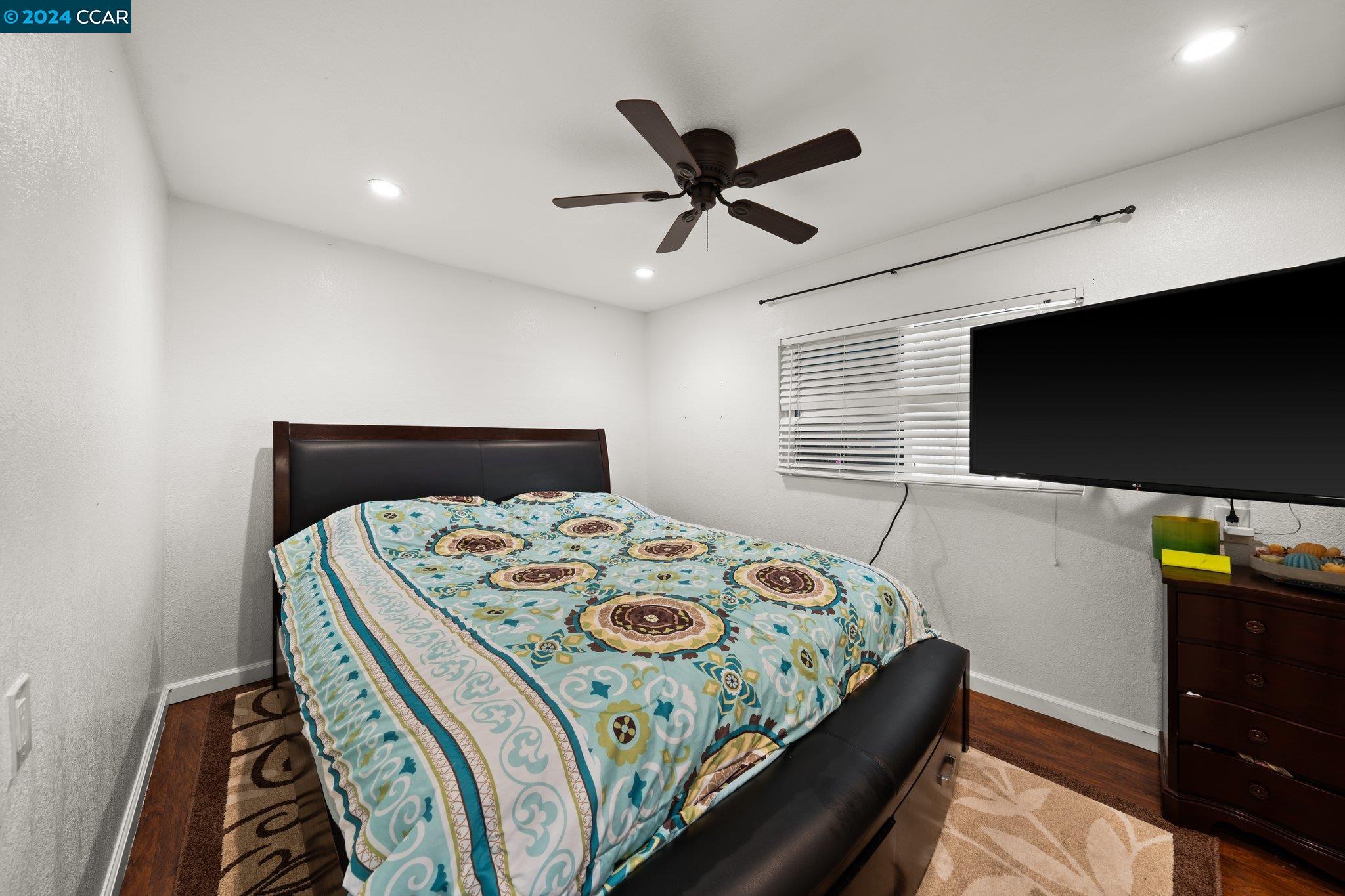 55 Pacifica Avenue, Unit 51 Bay Point, CA 94565 - Photo 15 of 35 a bedroom with a bed and a flat tv screen on a dresser