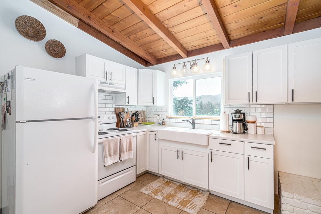 2030 Harbison Canyon Road El Cajon, CA 92019 - Photo 11 of 66 a kitchen with a refrigerator a sink and dishwasher with white cabinets