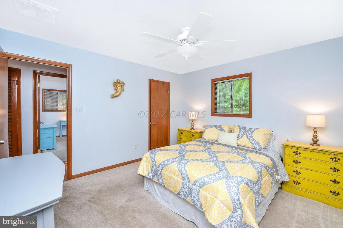 27 Brookside Road Ocean Pines, MD 21811 - Photo 23 of 44 a bedroom with a bed and a chandelier