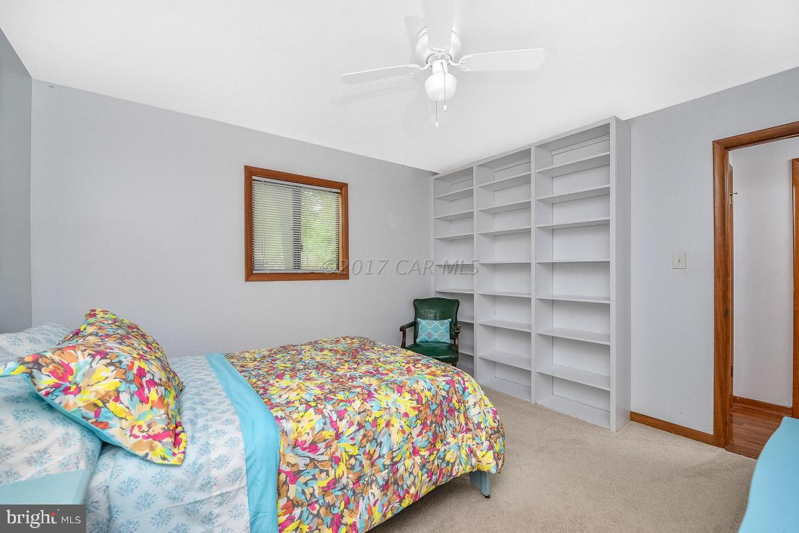 27 Brookside Road Ocean Pines, MD 21811 - Photo 32 of 44 a bedroom with a bed and a chandelier
