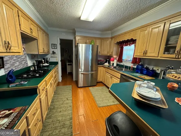 a kitchen with stainless steel appliances granite countertop a sink refrigerator stove and microwave