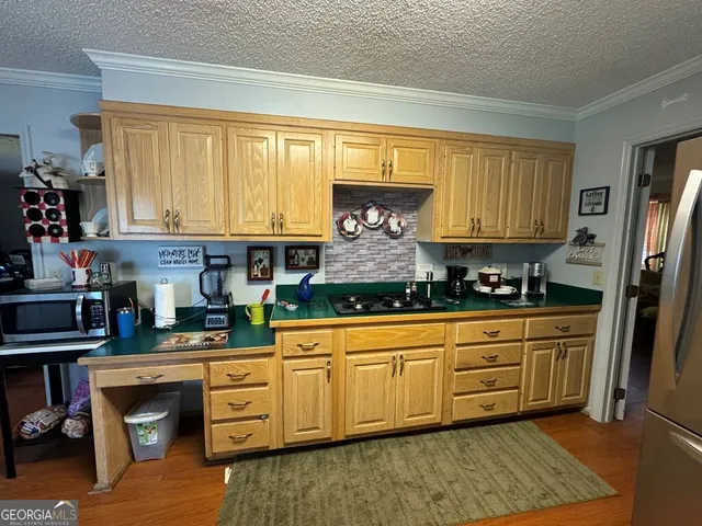 a kitchen with stainless steel appliances granite countertop a stove a sink and a refrigerator