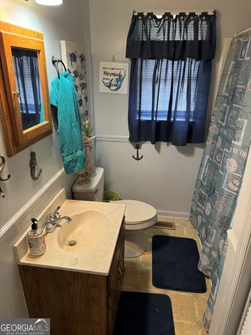 a bathroom with a sink toilet and mirror