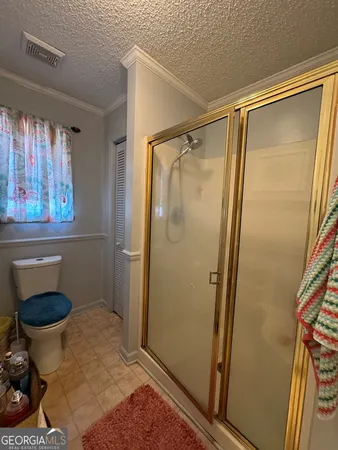 a bathroom with a toilet and a shower