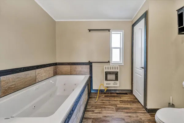 a spacious bathroom with a granite countertop sink a mirror and a bathtub