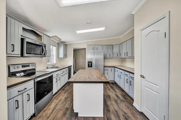 a kitchen with wooden cabinets a sink dishwasher and a stove with wooden floor