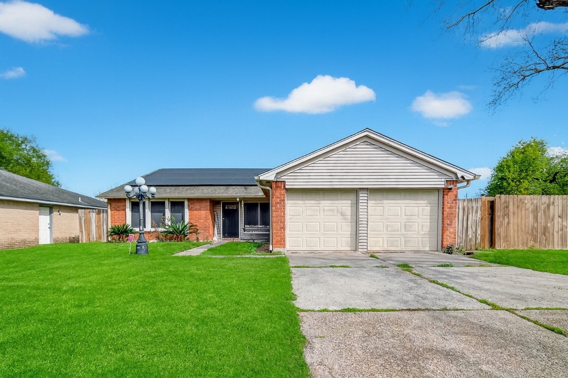 a view of house with a yard and potted plants