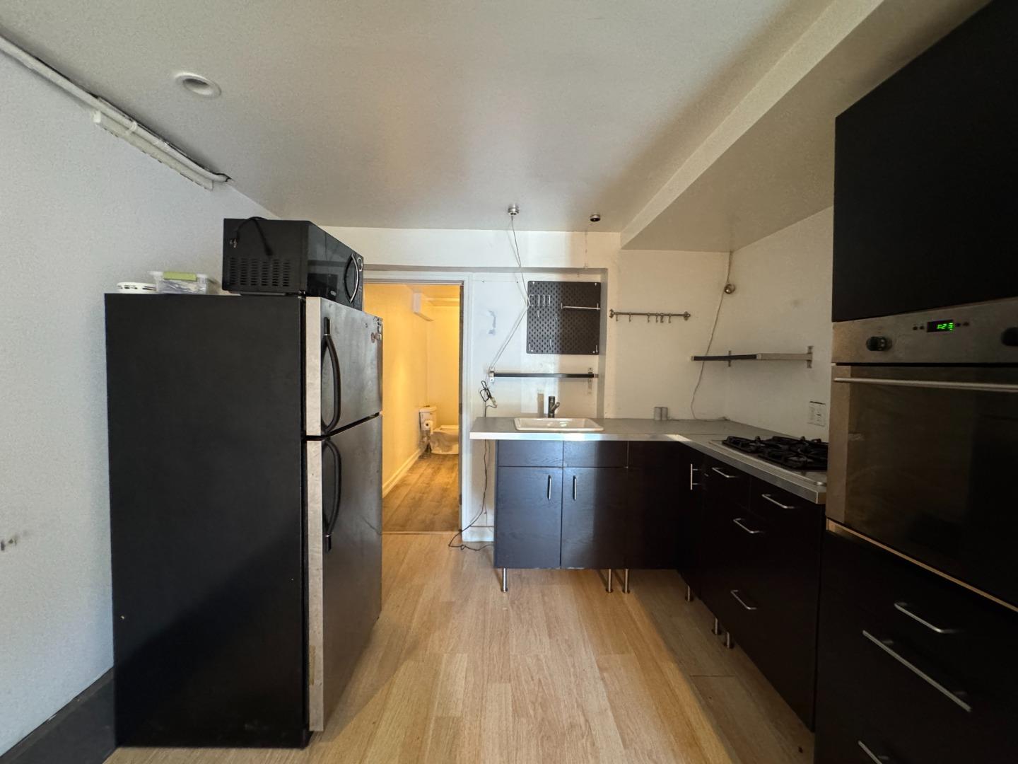 370 Bartlett Street, Unit 3 San Francisco, CA 94110 - Photo 28 of 35 a kitchen with a refrigerator a stove top oven a sink and dishwasher