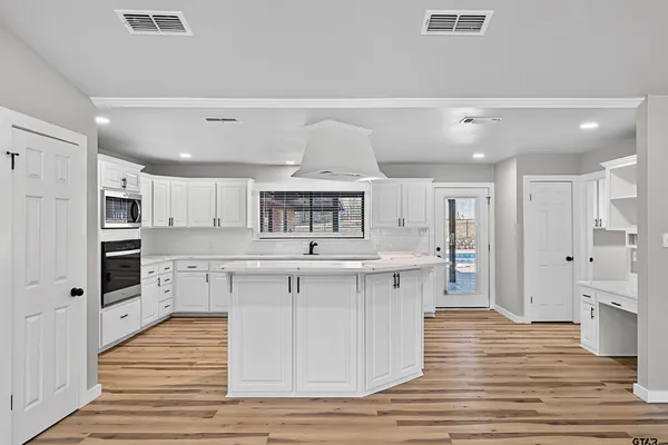 a kitchen with stainless steel appliances kitchen island a white cabinets sink and stove