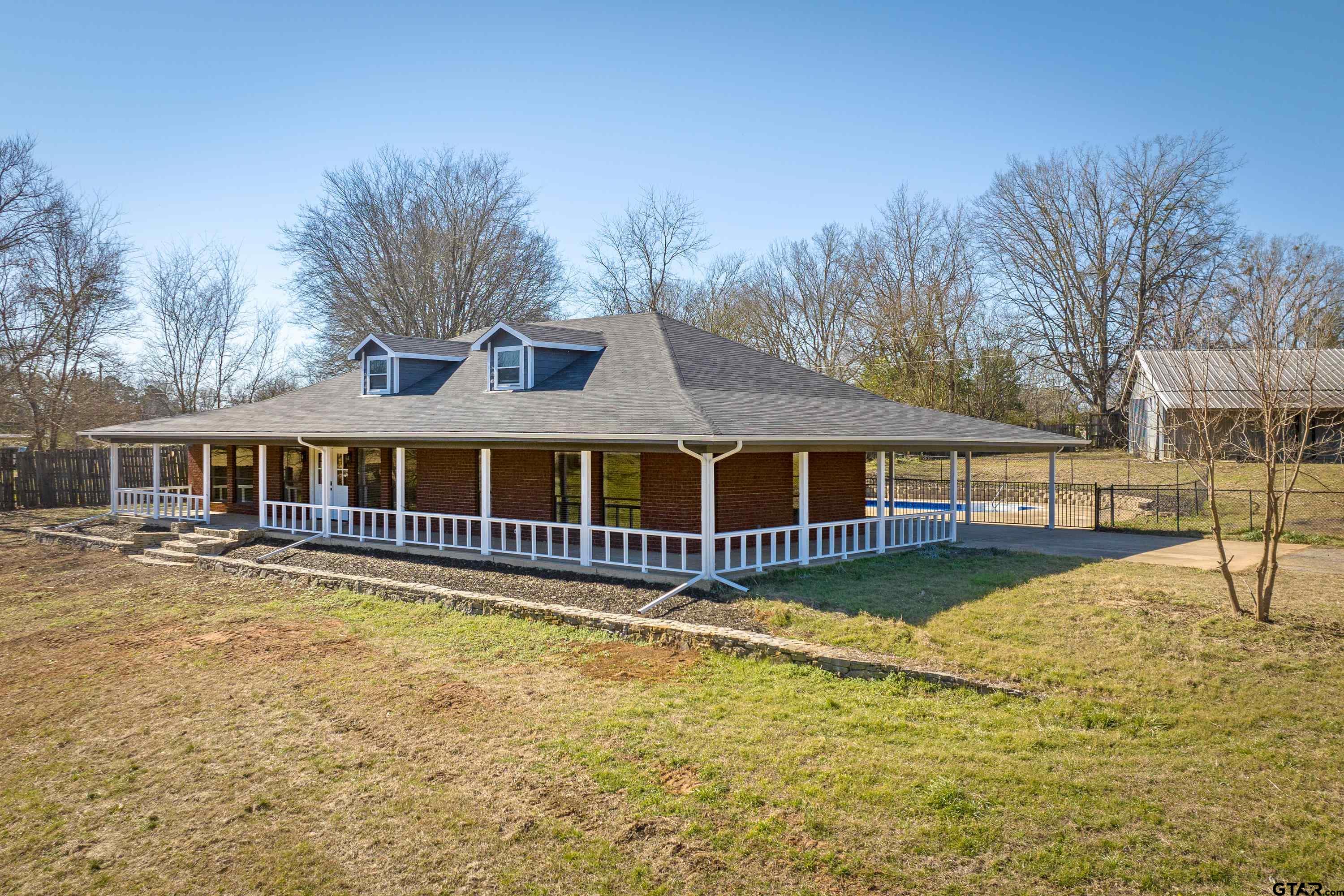 10418 East Fm 2011 Longview, TX 75603 - Photo 3 of 45 a front view of a house with a yard table and chairs