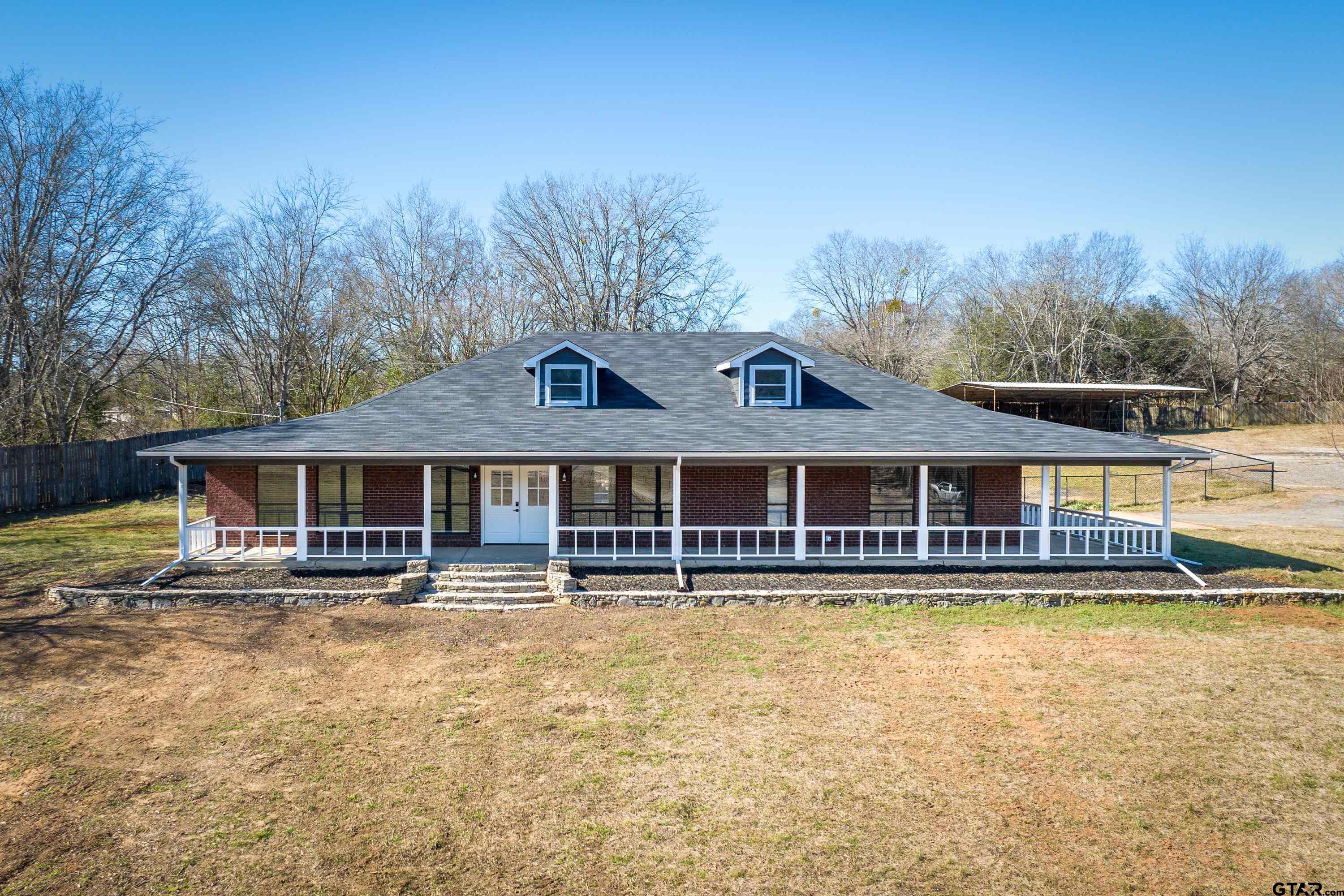 10418 East Fm 2011 Longview, TX 75603 - Photo 5 of 45 front view of a house with a yard patio and dining space