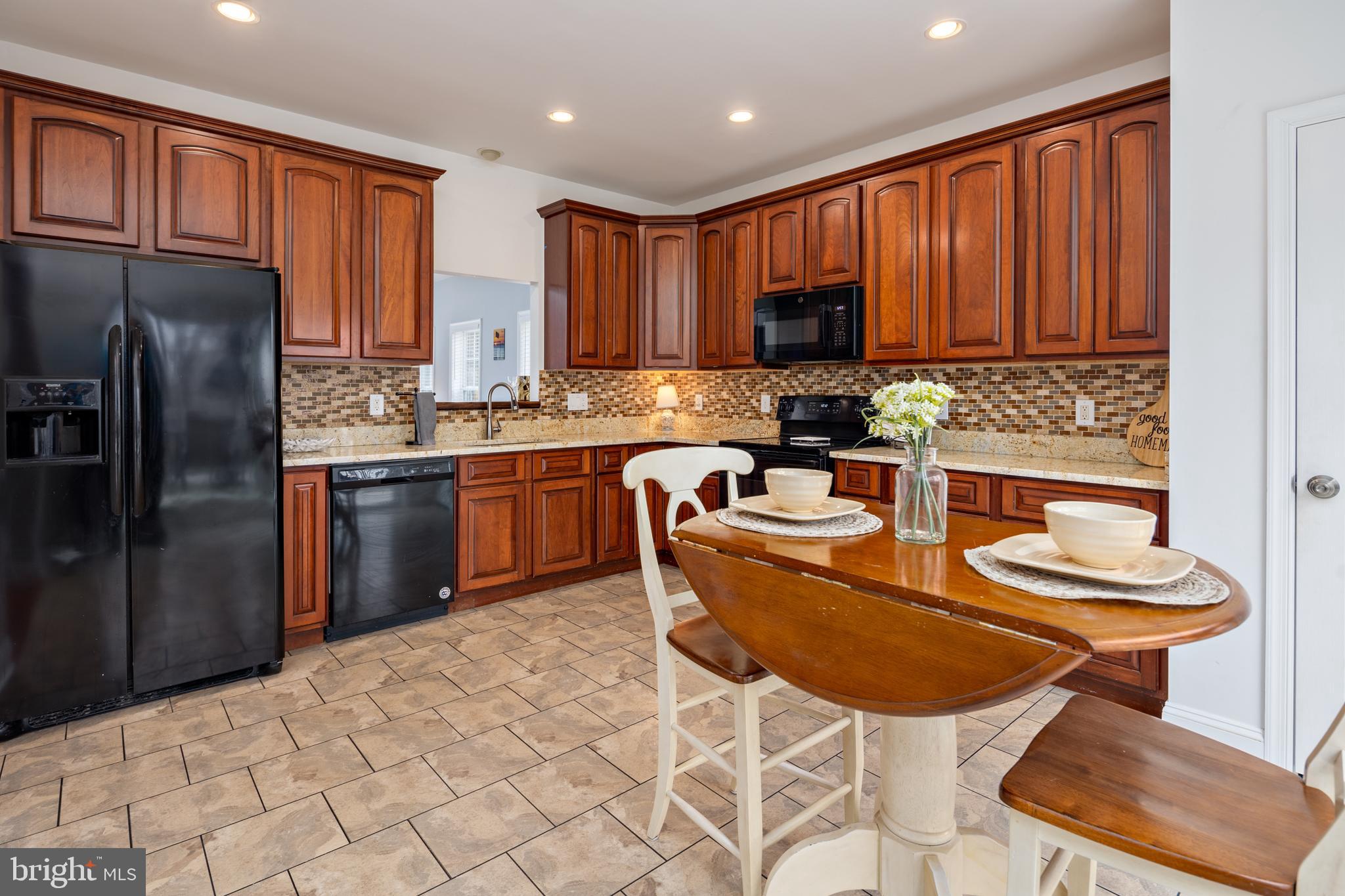 326 South Carolina Road Stevensville, MD 21666 - Photo 12 of 48 a kitchen with stainless steel appliances granite countertop a sink a stove a refrigerator a dining table and chairs