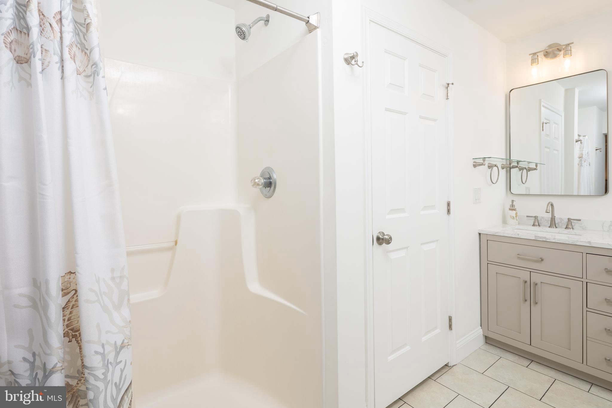 326 South Carolina Road Stevensville, MD 21666 - Photo 26 of 48 a bathroom with a shower sink and mirror