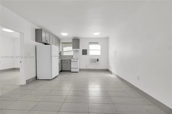 a view of a kitchen with refrigerator and white cabinets