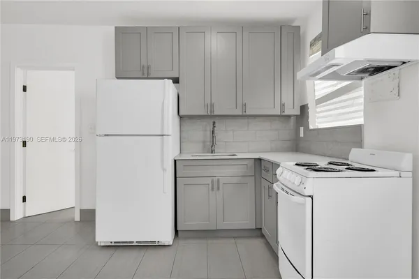 a kitchen with a refrigerator sink stove and cabinets